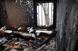 a lakás szobájában keletkezett tűzben a képen az összeégett matrac, a kormozódott falfelület és ruhák látszanak