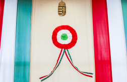 Március tizenötödiki díszítés - a kép két oldalán a nemzeti színek, középen egy nagy kokárda, felette a címer