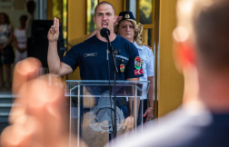 Kalmár Gergely tűzoltó őrmester épp előolvassa a tiszthelyettesi fogadalmat a pulpitus előtt, keze eskühöz emelve