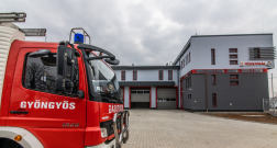 Gyöngyösi hivatásos tűzoltó parancsnokság szerkapui és épület egy része, előtte egy tűzoltóautóval.