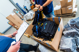 A megyei kollégák átveszik a hátizsákokat a raktárban.