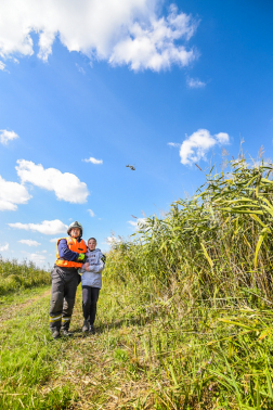 Az egyik tűzoltó megtalálta az egyik eltévedt utast, háttérben a levegőben egy helikopter.